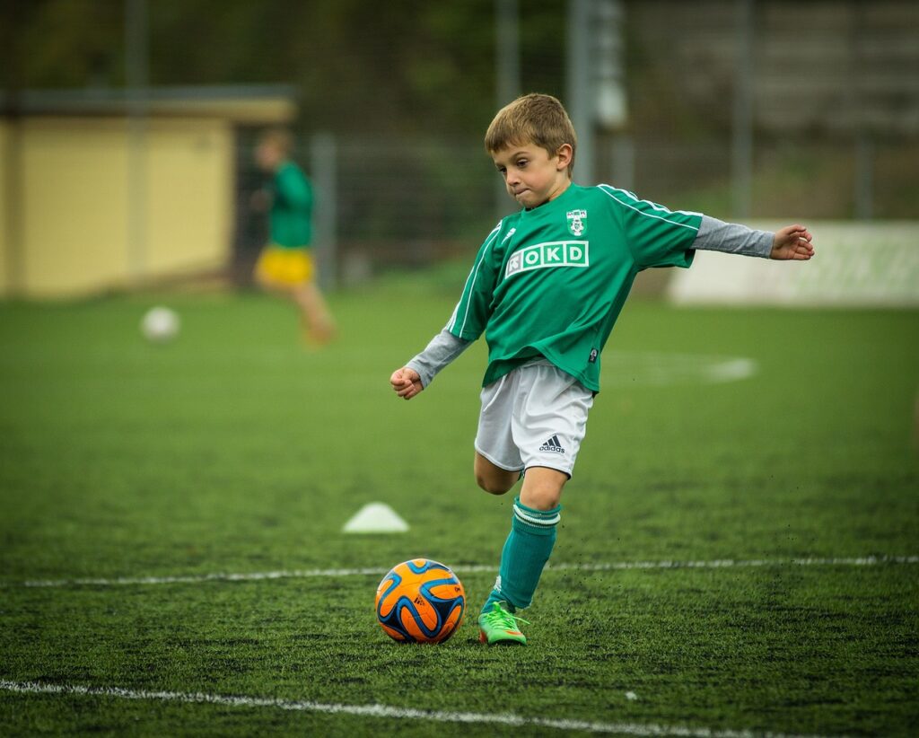 子供がサッカーボールを蹴る写真